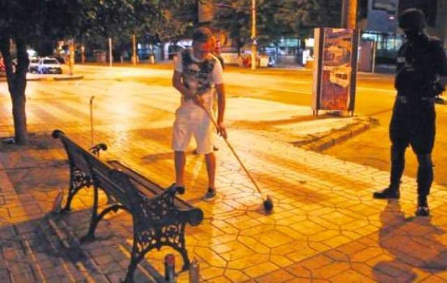 Şmecheri de cartier, făcuţi de râs în public. Au fost pedepsiţi de mascaţi să măture trotuarele