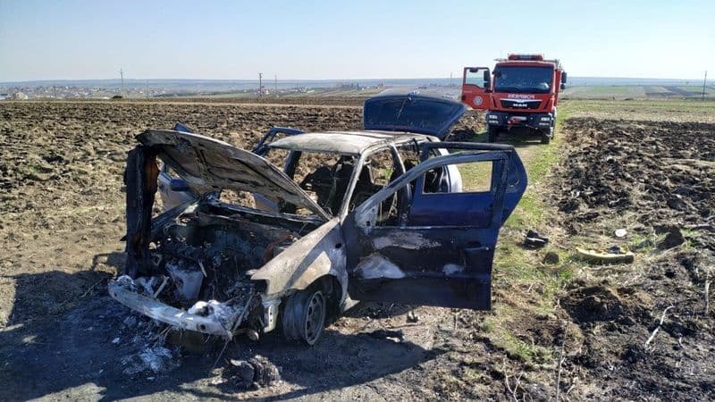 Mașină distrusă de foc după ce șoferul a oprit să stingă un incendiu de vegetație - FOTO