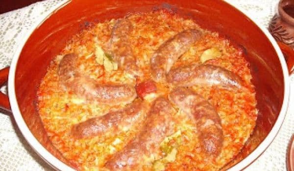 Varză călită cu cârnați de casă, în vas ceramic