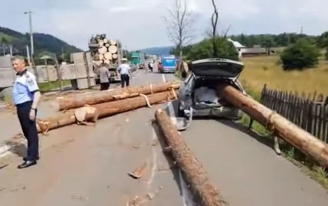Grav accident de circulație! Buștenii dintr-un camion au căzut pe o mașină - FOTO