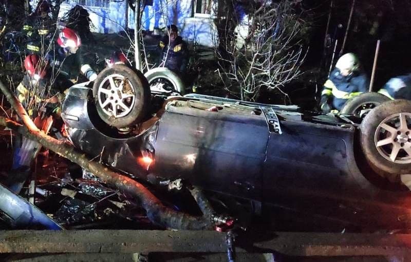 Accident! Un bărbat a rămas încarcerat după ce a lovit un copac și s-a răsturnat cu mașina într-o curte - FOTO