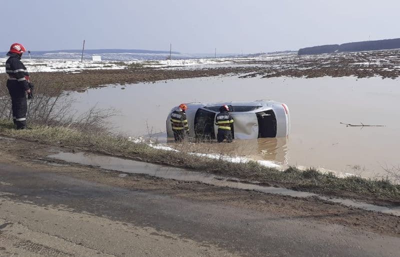 Accident! Doi tineri s-au răsturnat cu mașina într-o baltă formată ca urmare a topirii zăpezii - FOTO