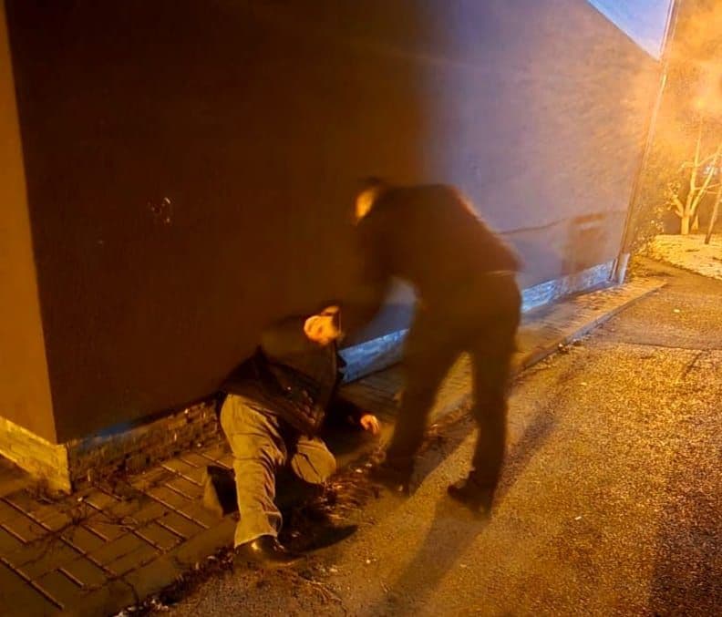 Bărbat accidentat căzut pe trotuar, ajutat de un jandarm la ieșirea din serviciu