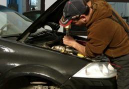 Mecanic auto cercetat pentru reparații la o mașină implicată într-un accident