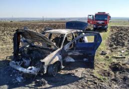Mașină distrusă de foc după ce șoferul a oprit să stingă un incendiu de vegetație - FOTO