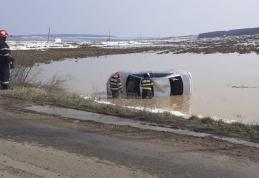 Accident! Doi tineri s-au răsturnat cu mașina într-o baltă formată ca urmare a topirii zăpezii - FOTO