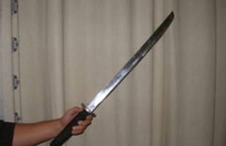 Bărbat cercetat după ce a amenințat cu sabia un vecin