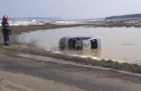 Accident! Doi tineri s-au răsturnat cu mașina într-o baltă formată ca urmare a topirii zăpezii - FOTO