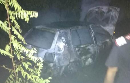 Autoturism parcat în fața unei case mistuit de flăcări