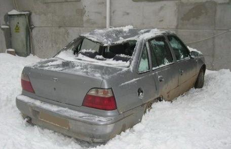 Autoturism avariat de zăpada căzută de pe un bloc