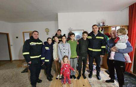 Privind pe geam și parcă așteptând să vină cineva.... Bucurii făcute de pompierii de Moș Nicolae