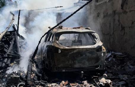 Un garaj în care se afla o mașină și mai multe bunuri distruse într-un incendiu violent