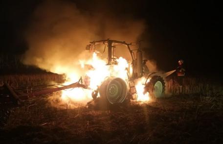 Tractor parcat într-o gospodărie, mistuit de flăcări