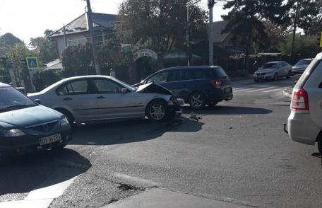 Mașini avariate, semafor distrus și o intersecție blocată în urma unui accident produs din neatenție - FOTO