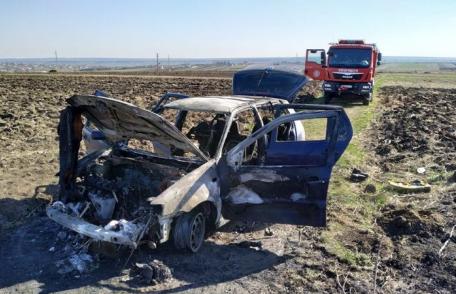 Mașină distrusă de foc după ce șoferul a oprit să stingă un incendiu de vegetație - FOTO