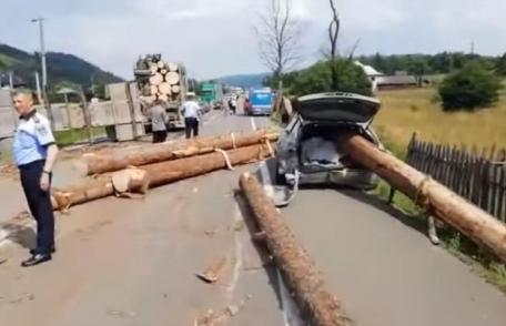 Grav accident de circulație! Buștenii dintr-un camion au căzut pe o mașină - FOTO